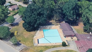 Satellite image of overhanging tree posing a safety hazard above the pool at Wilmington's Surratte Park before removal by Strobert Tree Services
